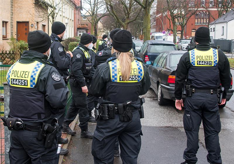Bombe in Wilhelmsburg entschärft - Corona und Sturm erschweren Einsatz Nach dem Bombenfund evakuieren Polizisten im Stadtteil Wilhelmsburg einen Straßenzug. Foto: Daniel Bockwoldt/dpa
