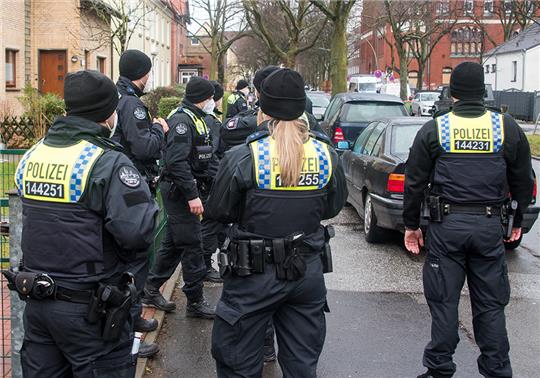 Nach dem Bombenfund evakuieren Polizisten im Stadtteil Wilhelmsburg einen Straßenzug. Foto: Daniel Bockwoldt/dpa