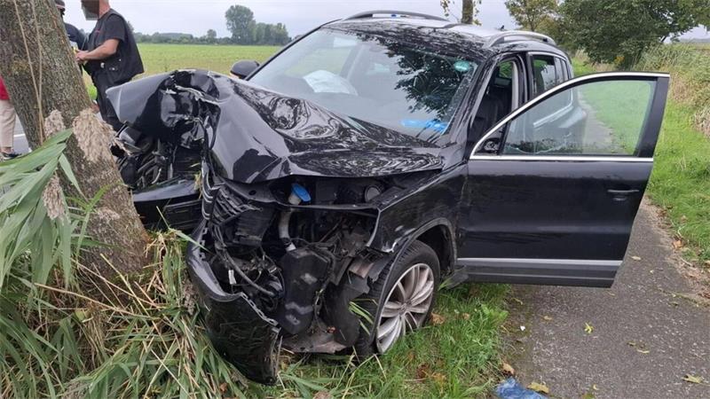 Nach dem Unfall steht der schwerbeschädigte Wagen am Baum. Der Fahrer wird ins Krankenhaus gebracht.