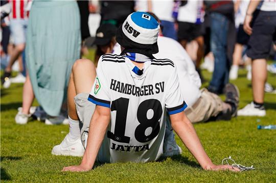 Nach der Nachricht des 3:2 von Heidenheim in Regensburg sitzt ein Hamburger Fan am Boden.