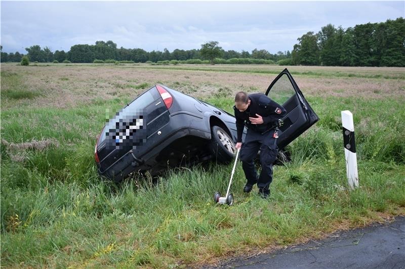 Nach der Rettung vermisst ein Polizist die Unfallstelle . Der Ford Mondeo Kombi war in einer Rechtskurve von der Fahrbahn abgekommen. Foto: Vasel