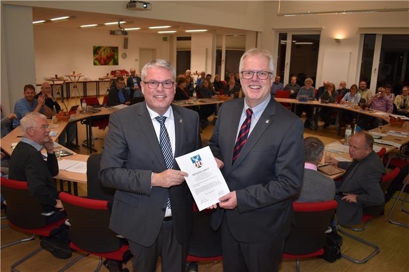 Nach der Vereidigung durch den stellvertretenden Bürgermeister Michael Eble (CDU, links) zeigt der neue Bürgermeister der Gemeinde Jork, Matthias Riel (parteilos), stolz seine Urkunde. Foto: Vasel