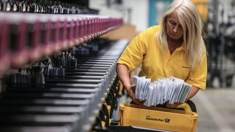 Postreform: Das ändert sich für Kunden beim Brief- und Paketversand Eine Mitarbeiterin der Post sortiert Briefe.