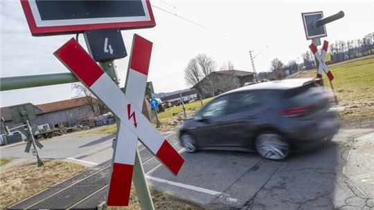 Ein Pkw fährt über einen Bahnübergang.