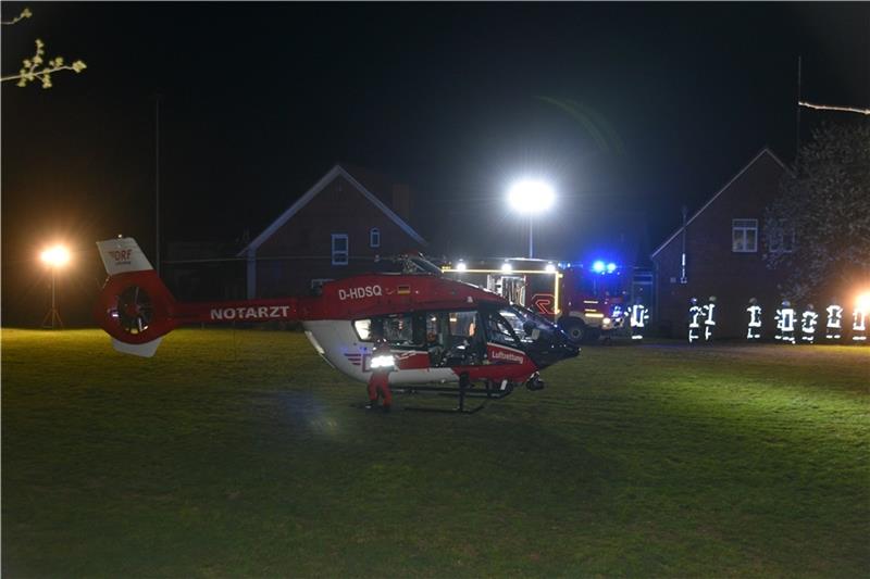 Nach einem Verkehrsunfall landet ein Rettungshubschrauber nachts auf dem Sportplatz von Issendorf. Die Rasenfläche wird ausgeleuchtet von Einsatzkräften der Feuerwehr. Foto: Beneke