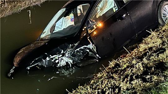 Nach einer Kollision bei Drochtersen-Ritsch wird ein Auto in den Fleth geschleudert und versinkt teilweise im Wasser.