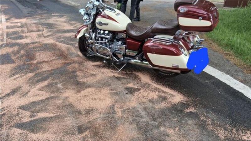 Nachdem das Motorrad wieder aufgerichtet ist, entfernt die Feuerwehr auslaufende Betriebsstoffe mit Bindemitteln.