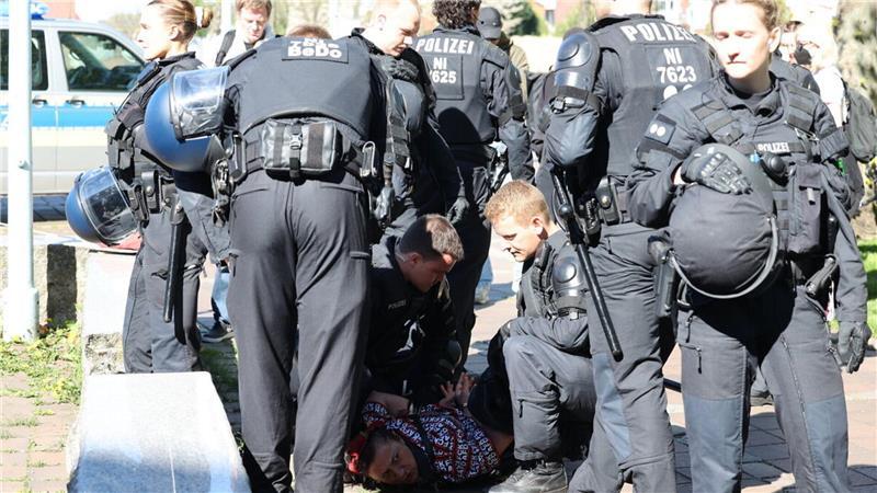 Video von Cuxhavener GfD-Demo wirft Fragen auf: Polizei verteidigt Einsatz gegen Frau Nachdem sie von einem Beamten geschubst wurde, ging die Frau zu Boden und wehrte sich gegen die Festnahme.