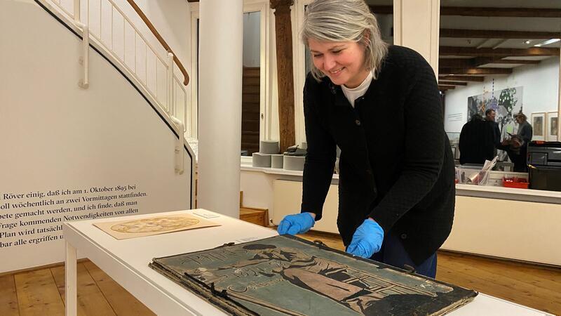 Nachlass einer selbstbewusst schaffenden Frau: Kuratorin Regina Wetjen platziert die Mappe von Minna Schwerdtfeger vom Pariser Studienaufenthalt in einer der Ausstellungsvitrinen.