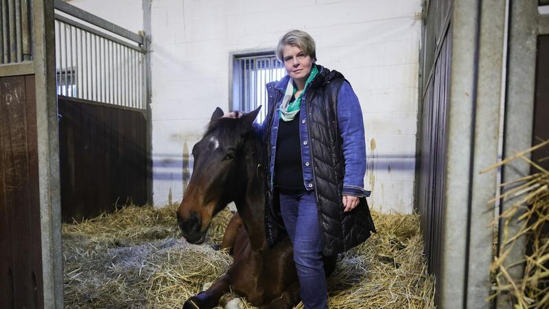 Nadine Wilkens, Landwirtin und Inhaberin einer Pferdepension, steht neben einem ihrer Pferde.