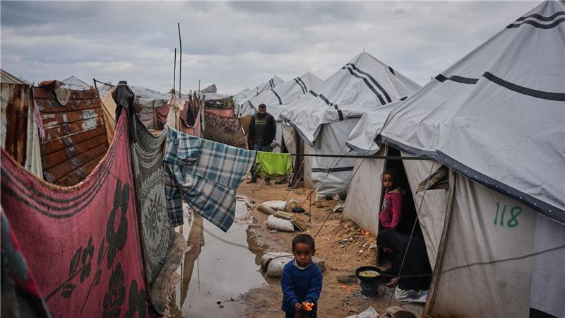 Nanaa Abu Jari kocht in Nuseirat im zentralen Gazastreifen vor ihrem Zelt, das von Regenwasser überflutet wurde..