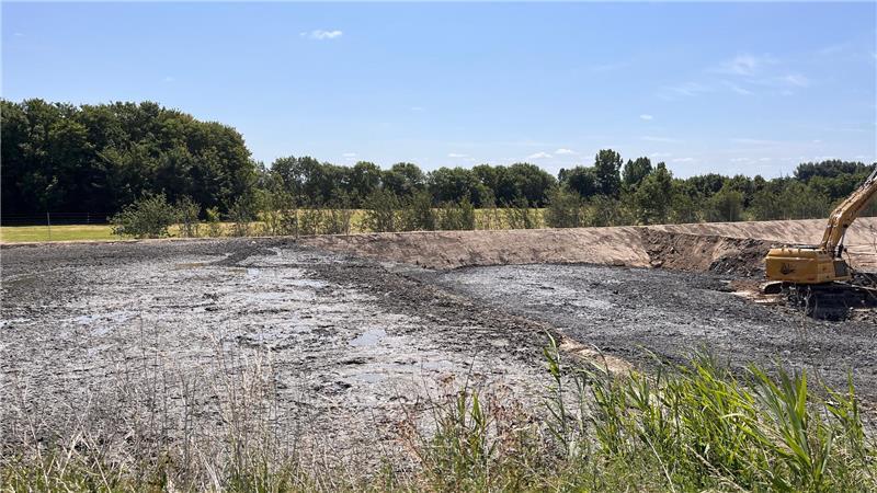 Ärger um Hafenschlick-Depot an der Oste: Lager ohne Genehmigung gebaut Nass glänzt der Hafenschlick, den der Bagger zu einer dichten Masse türmt.