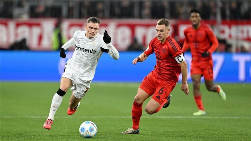 Nationalmannschafts-Kollegen im rasanten Duell: Leverkusens Florian Wirtz (l) und Bayerns Joshua Kimmich.