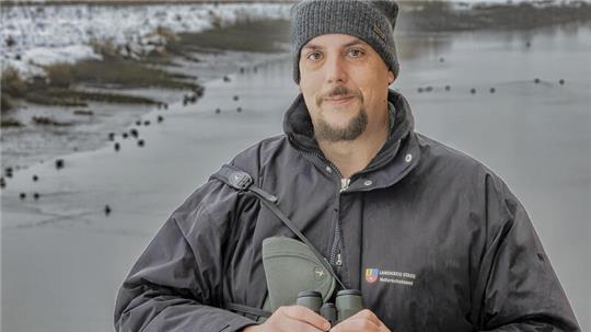 Naturschutzwart Andreas Nees mit seiner wichtigsten Ausrüstung, dem Fernglas, am Sperrwerk des Ruthenstromes in Südkehdingen.