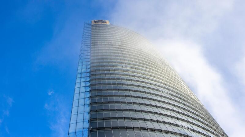 DHL macht bessere Geschäfte in Deutschland Nebelschwaden ziehen an der Zentrale von DHL, dem Posttower, vorbei. Oben angebracht ist ein Posthorn-Logo.