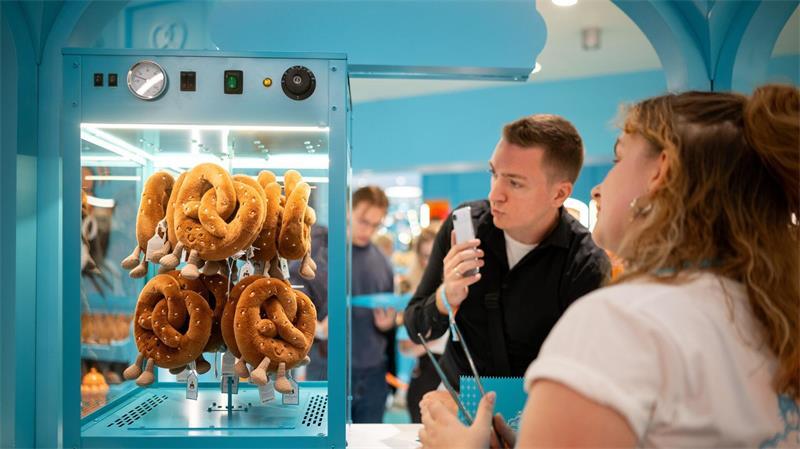Anstehen für Plüsch-Bratwürste auf dem Grill Neben Bratwürsten, Zuckerwatte und Eiskaffee gibt es auch Brezeln aus Plüsch.