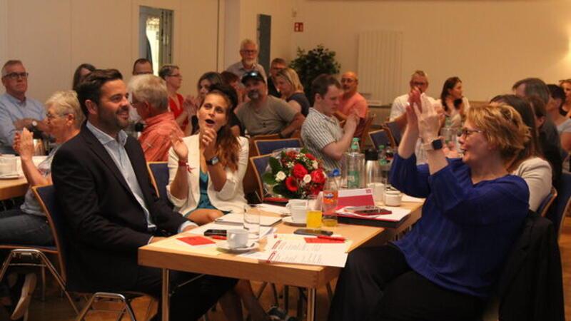 Neben Daniel Schneider (l.) applaudiert SPD-Bundestagsabgeordnete Maja Wallstein (Cottbus), gegenüber Innenministerin Daniela Behrens.