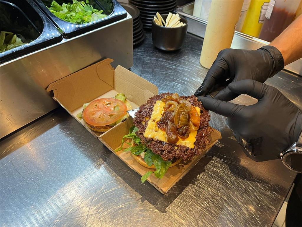 Neben Tomate und Gürkchen kommt auch eine Spezialsoße auf den Burger.