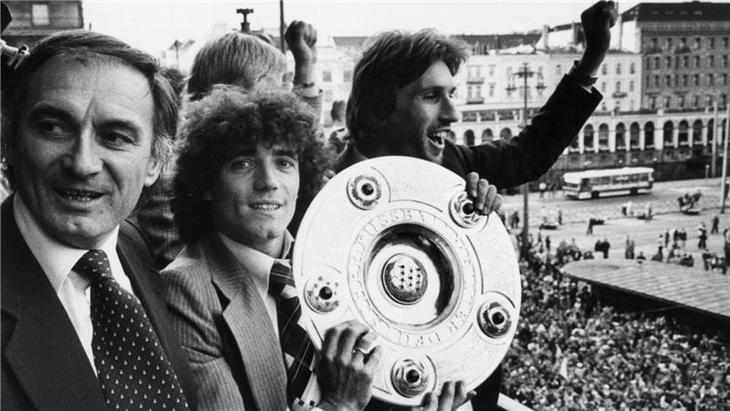 Neben dem jugoslawischen Trainer Branco Zebec (l) und Abwehrspieler Manfred Kaltz (r) zeigt der englische Stürmerstar Kevin Keegan (M) vom Hamburger SV am 09.06.1979 die Meisterschale. 

