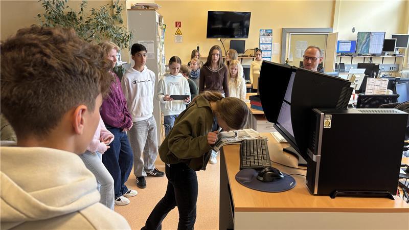 Neela (14) vom Vincent Lübeck Gymnasium in Stade schaut sich durch die Lupe an, ob der Zeitungsdruck gelungen ist.