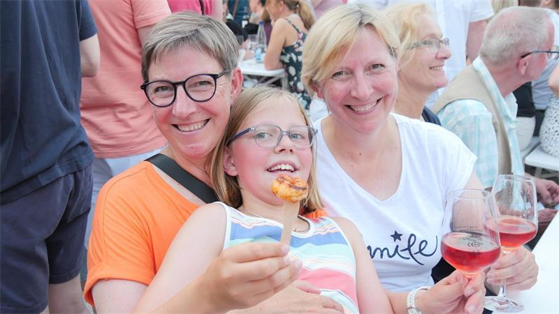 Süße Männer, trockener Wein: Buxtehuder Weinfest sorgt für Schmunzler Neele genießt Scampis mit ordentlich Knobi während Mutter Dorte und Tante Frauke einen trockenen Rosé testen. Die drei sind bestens ausgestattet mit zusätzlichem eigenen Knabberkram für zwischendurch.
