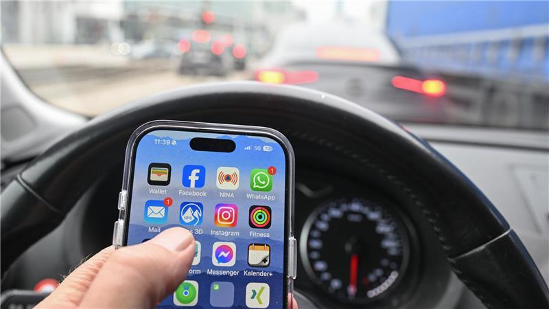 Nein, schlechte Idee: Wer im Auto ein Smartphone nutzen will, fährt besser rechts ran - und schaltet den Motor ab. Sonst könnte es teuer werden - gefährlich allemal. 

