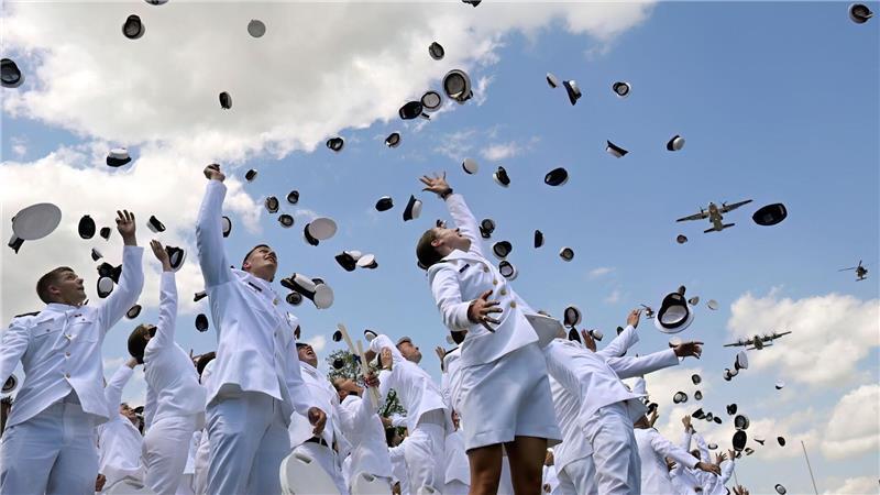 Neu ernannte Fähnriche werfen ihre Mützen zum Abschluss der Feierlichkeiten an der United States Coast Guard Academy in New London in den USA.