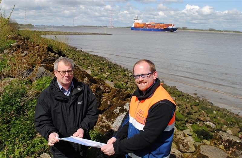 Neues Deckwerk auf einer Länge von 250 Metern: Oberdeichrichter Klaus Jarck (links) und Ruben Cordes vom Wasser- und Schifffahrtsamt Hamburg (WSA) studieren an der Elbe die Pläne für die Instandsetzungsarbeiten im Deichvorland nördlich des 