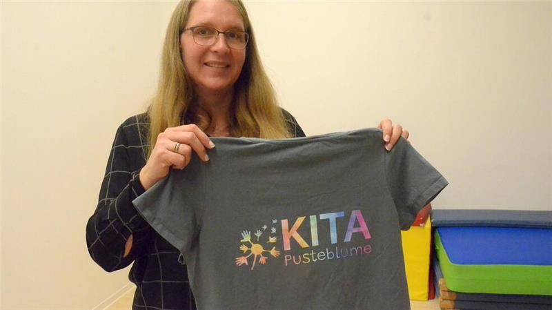 Größer, heller, moderner: Das ist die neue Kita Pusteblume Nicht nur das Gebäude ist neu. Leiterin Erdmute Beckmann zeigt das neue Logo der Kita Pusteblume in Bargstedt: eine Pusteblume aus Händen.