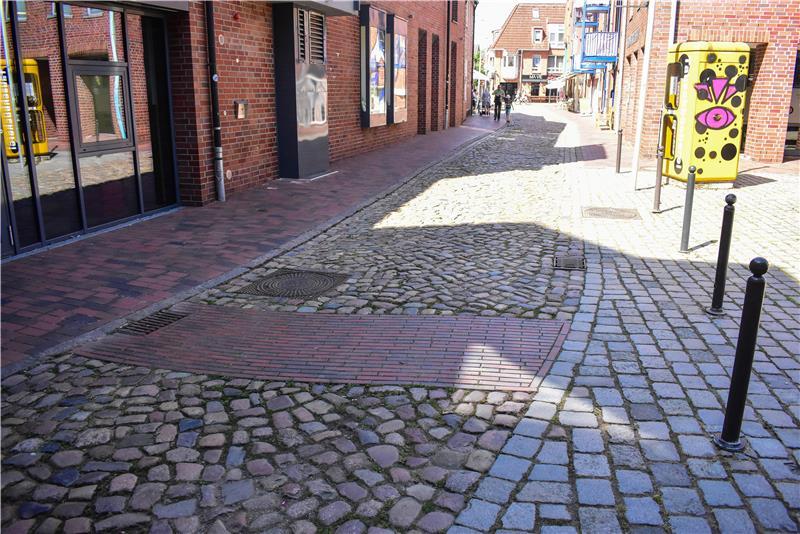 Hollywoodreif: Mit ChatGPT auf Entdeckungsreise durch Buxtehude Ein ebener, kleiner Weg durchzieht eine Straße aus Kopfsteinpflaster.