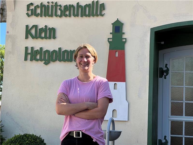 Nicole Müller, die neue Nummer eins der Bützflether Schützen, vor dem Eingang zur „Schützenhalle Klein Helgoland“ mit stilisiertem Leuchtturm in den original Helgoländer Farben Grün-Rot-Weiß. Foto: Strüning