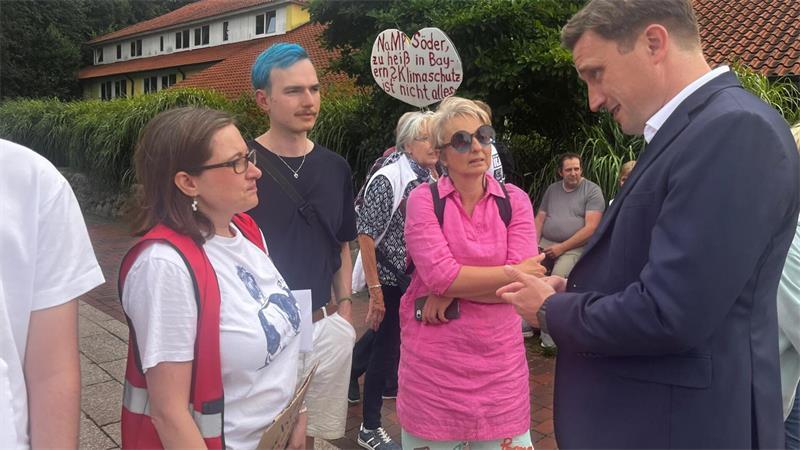 Drinnen Lacher, draußen Protest: So lief Söders Stade-Auftritt Niedersachsens CDU-Chef Sebastian Lechner im Gespräch mit Demonstrierenden in Stade.