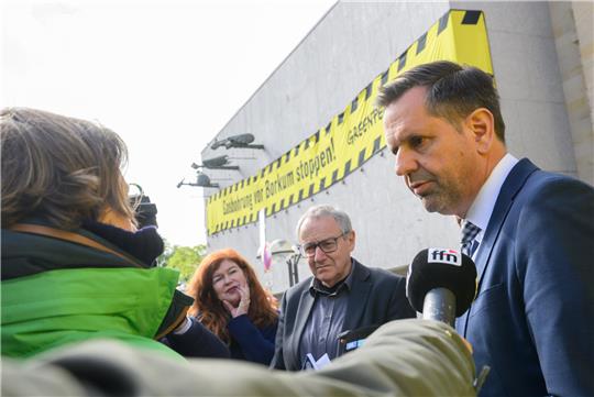 Niedersachsens Wirtschaftsminister Olaf Lies spricht mit Aktivisten der Greenpeace-Protestaktion. Foto: Julian Stratenschulte/dpa