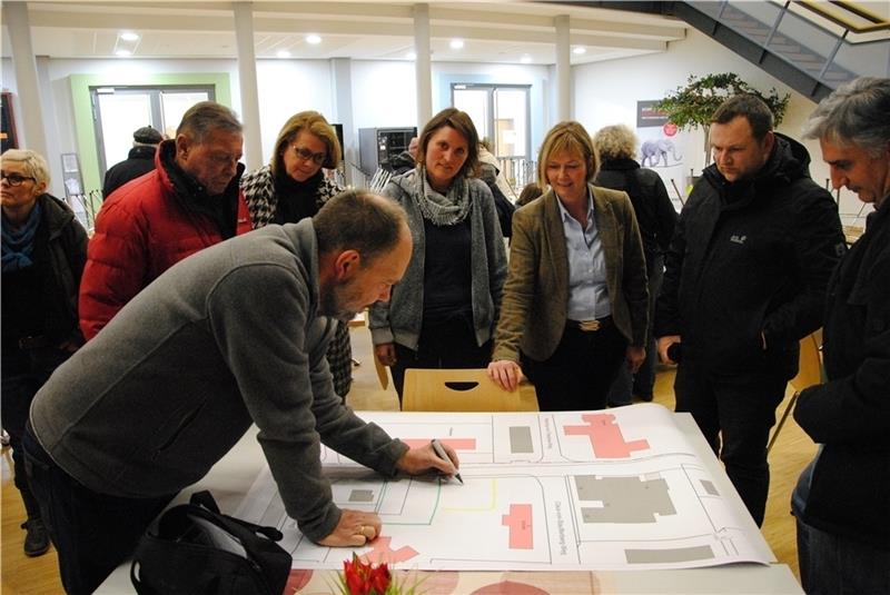 Nils Jacobs vom Fachbereich Bauen erläutert eine Skizze zu Ottenbecks „Ortsmitte“ . Bürger und Bürgermeisterin Silvia Nieber (zweite von rechts) hören zu. Foto Stief