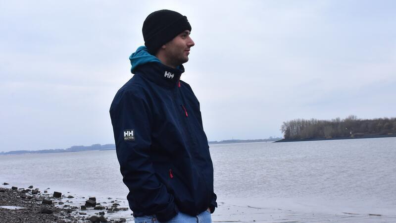 Matti Pleßmann steht am Ufer und blickt auf die Elbe.