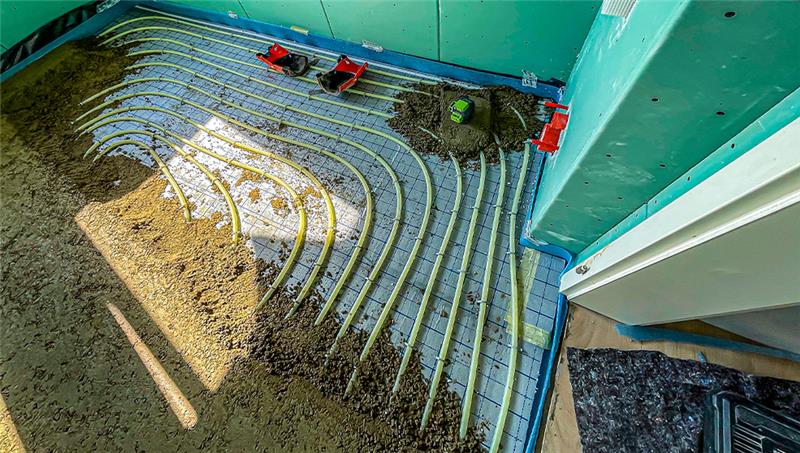 Nur beim Einbau ist sie zu sehen: Die Fußbodenheizung verschwindet danach unter einem Estrich. Foto: Alexander Ludwig/dpa-tmn
