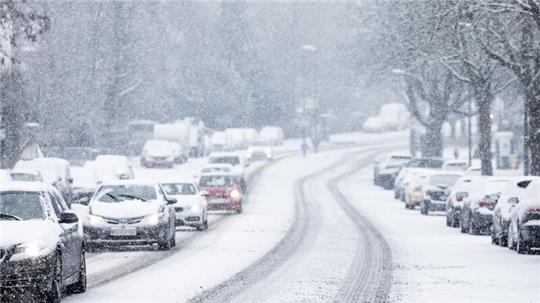 Nur langsam kommen Autos in der Kölner Innenstadt im dichten Schneetreiben voran.