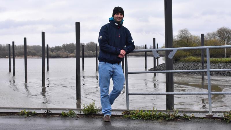 Matti Pleßmann steht am Yachthafen in Neuenschleuse und lehnt mit dem linken Arm an einer Reling.