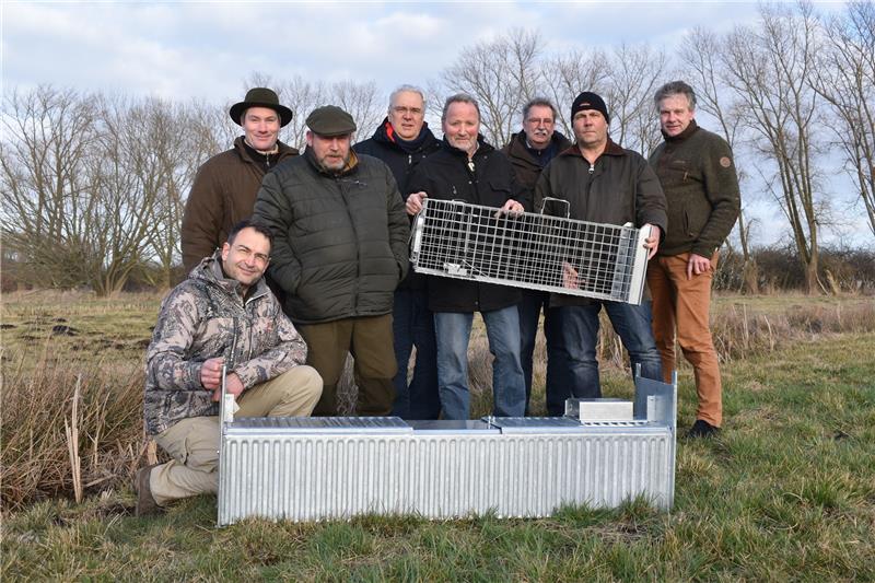 Oberdeichrichter Wilhelm Ulferts (Vierter von links) und Verbandsvorsteher Hans Alpers-Janke (Fünfter von links) übergeben Nutria-Fallen an die Vertreter der Kreisjägerschaft und die Hegeringe Buxtehude und Jork.  Foto Vasel