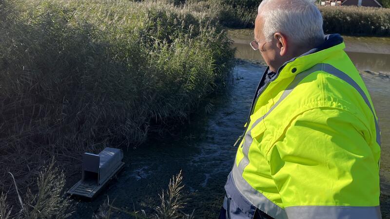Oberdeichrichter Wilhelm Ulferts blickt auf eine Nutria-Falle an der Este.