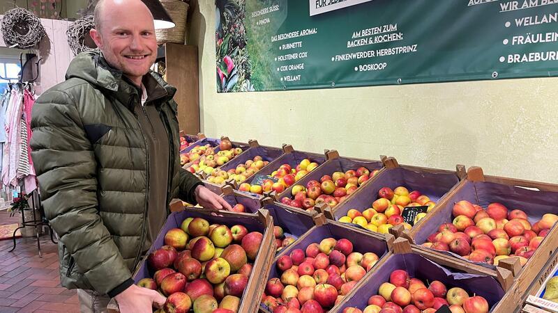 Obstbauer Jonas Cohrs bringt neue Äpfel in den Hofladen, dank Solarstrom bleiben sie bis in den Sommer erntefrisch.