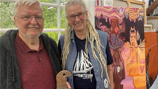 Michael Jalowczarz und Christa Donatius stehen vor den Fenstern des lichtdurchfluteten Ateliers mit Bildern der Malerein im Hintergrund
