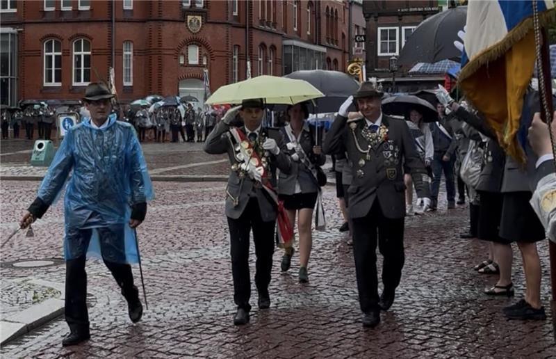 Die Stader Schützen haben wieder ein volles Königshaus Ohne Regenschirm ging es kaum: Der Schützenmarsch bewegt sich über den Pferdemarkt.