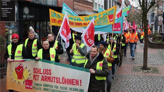 Streikende ziehen mit Trillerpfeifen und Transparenten durch die Große Schmiedestraße in Stade.