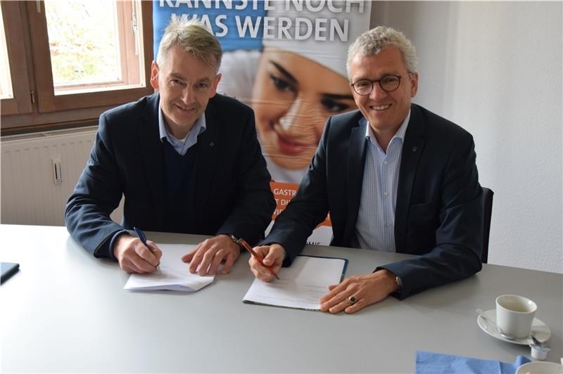 Olaf Wurm, 1. Vorsitzender des Dehoga Stade, und Detlef Pauls, Präsident des Dehoga Bremen, unterzeichnen in Stade die Kooperationsverträge. Fotos: Battmer