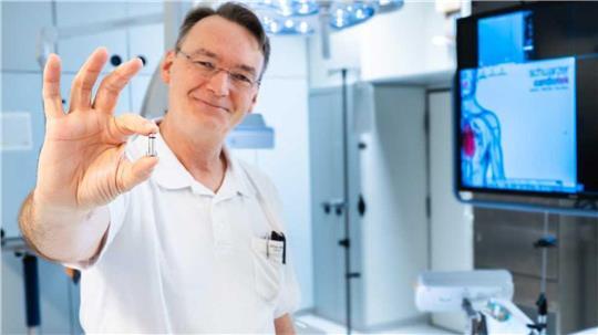 Oliver Marx hält den sondenlosen Einkammer-Herzschrittmacher in der Hand. Hier im Herzkatherlabor des Klinikums wurde das winzige Gerät erstmals einem Patienten implantiert.