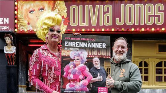 Olivia Jones und Türsteher Fabian Zahrt zeigen eines der neuen Plakate.