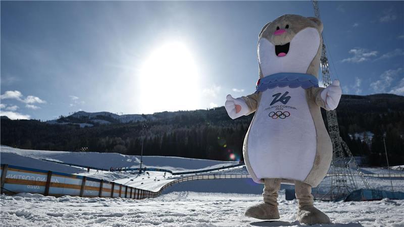 Olympia-Maskottchen Tina präsentiert sich im Langlaufstadion von Val di Fiemme