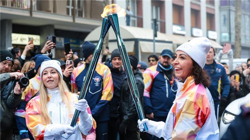 Olympische Winterspiele: Athletinnen beim Fackellauf mit der Flamme in Cortina D’ampezzo.