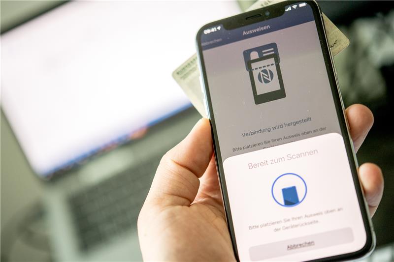 So funktioniert der Perso als Online-Ausweis Online ausweisen einfach gemacht: Wenn die "Ausweisapp2" dazu auffordert, hält man seinen Ausweis zum Scannen unters Smartphone und gibt sein PIN ein. Foto: Zacharie Scheurer/dpa